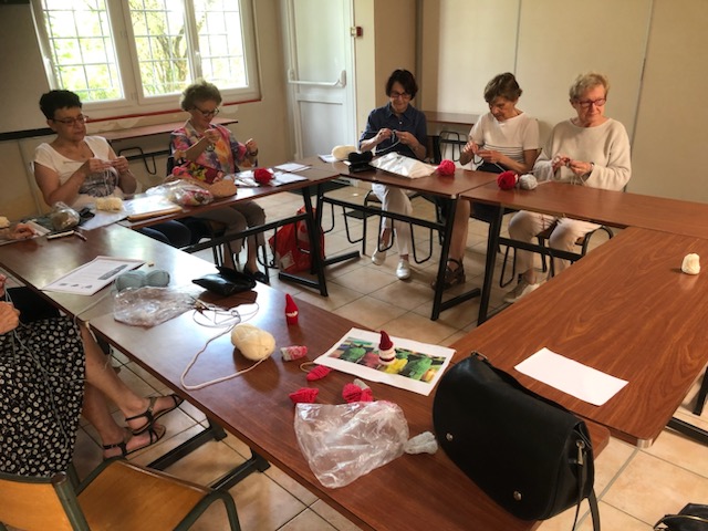 Des bonnets pour bouteilles tricotés lors du café sourire du Secours Catholique