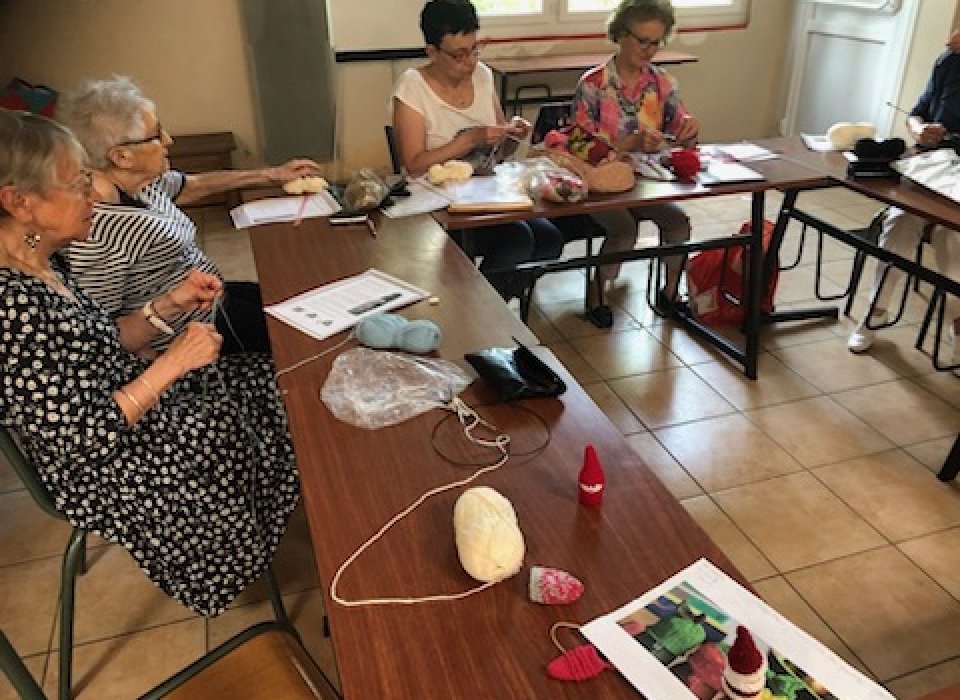 Des bonnets pour bouteilles tricotés lors du café sourire du Secours Catholique