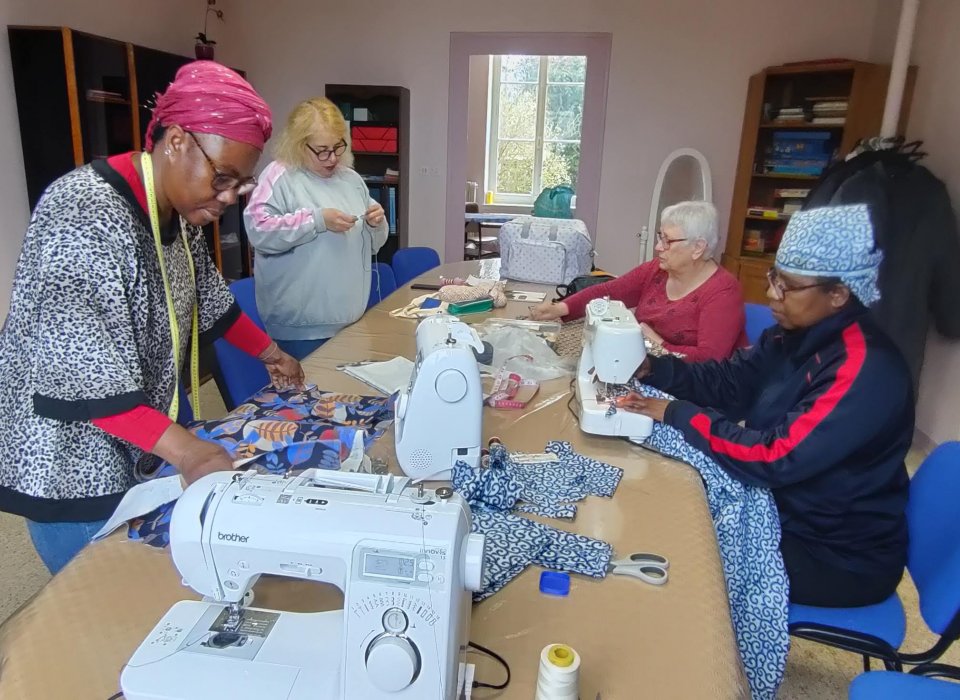 Léontine, à la machine à coudre, termine des vêtements pour ses enfants